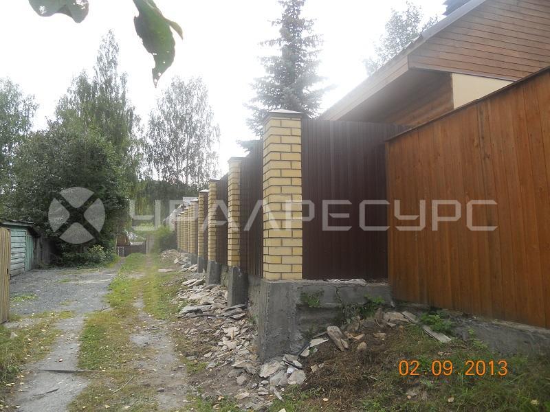 Забор из профлиста с каменными колоннами в пос. Шувакиш